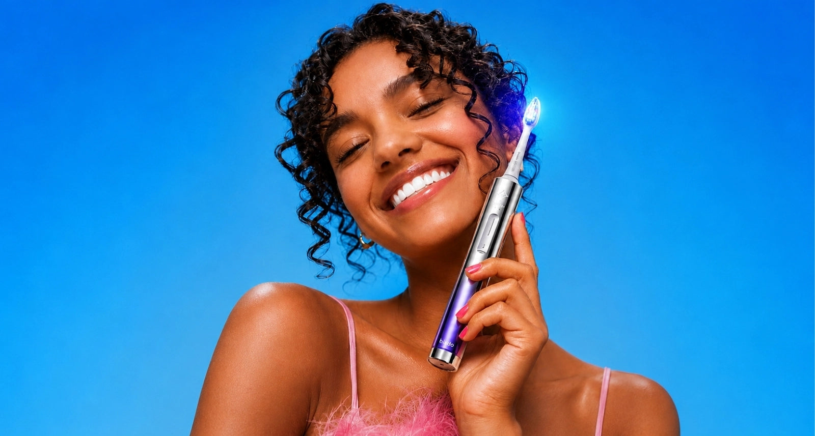 Conceptual Glossonic Brush PRO and whitening toothpaste in a silver studio composition