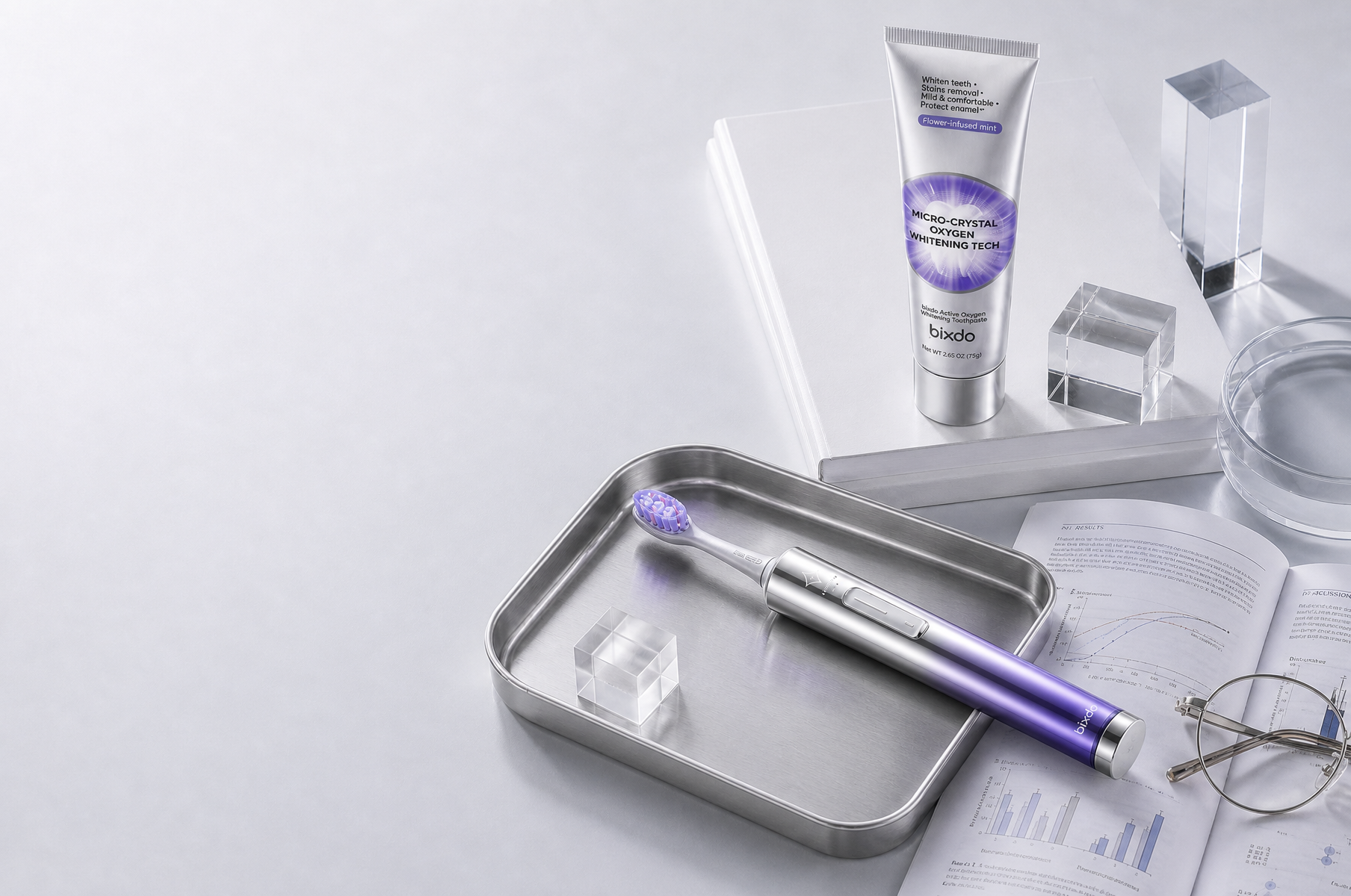 Conceptual Glossonic Brush PRO and whitening toothpaste in a silver studio setting